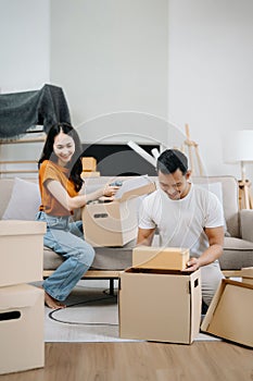 Happy asian young attractive couple man and woman with big boxes moving into a new house, new apartment for couple the new home,