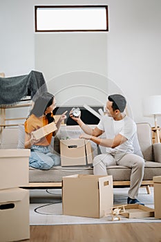 Happy asian young attractive couple man and woman with big boxes moving into a new house, new apartment for couple the new home,