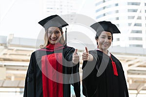 Happy Asian young beautiful graduate students with master and bachelor University degree with black board cap with red tassels