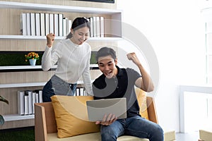 Happy Asian young Businesswoman and Business man working laptop computer on wood desk in Home office