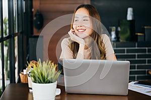 businesswoman sitting alone at cafe desk with laptop computer she looking out of