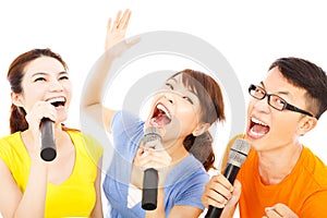 Happy asian young group having fun singing with microphone