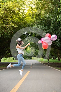 Happy asian young woman with colorful balloons