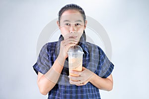 Happy Asian young woman is drinking Thai tea with milk. Popular beverage in Asia