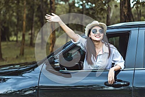 Happy Asian young woman enjoying a ride in a car