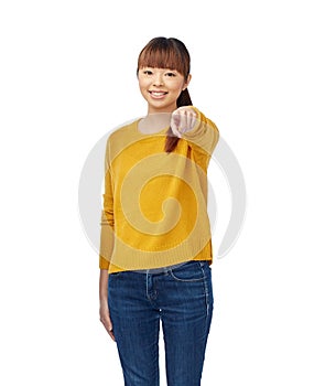 Happy asian young woman pointing finger on you
