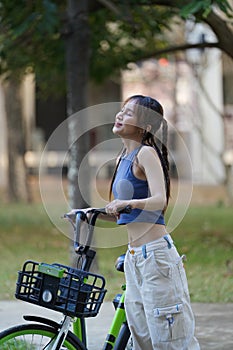 Happy Asian young woman ride bicycle in park, street city her smiling using bike of transportation, ECO friendly