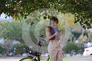 Happy Asian young woman ride bicycle in park, street city her smiling using bike of transportation, ECO friendly, People