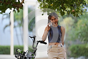 Happy Asian young woman ride bicycle in park, street city her smiling using bike of transportation, ECO friendly, People