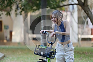 Happy Asian young woman ride bicycle in park, street city her smiling using bike of transportation, ECO friendly, People