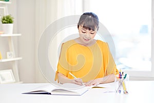 Happy asian young woman student learning at home