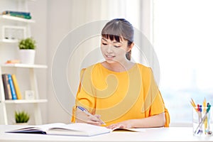 Happy asian young woman student learning at home