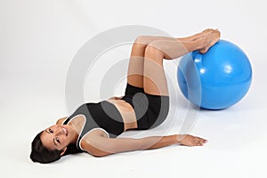 Happy athletic young woman using exercise ball