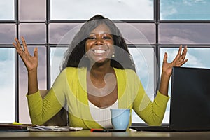 Happy and attractive black African American business woman smiling confident working at office computer desk in successful