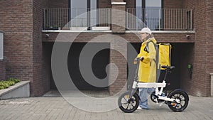 Happy Attractive Caucasian Woman Courier Walking With Bike In the Building, Delivering. Fast Delivery. Postal Lady