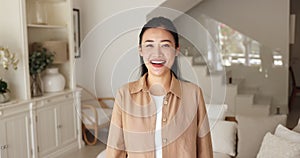 Happy attractive Chinese woman posing in modern living room