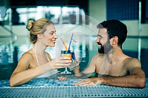 Happy attractive couple relaxing in swimming pool