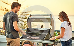 Happy attractive couple standing together on a rooftop barbecue