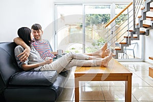 Happy attractive couple talking sitting on the couch in modern h