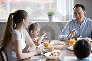 Happy attractive family having healthy breakfast sitting in the