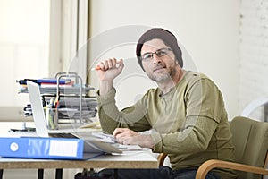 Happy attractive hipster businessman working with computer laptop at home office