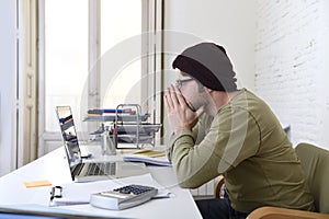 Happy attractive hipster businessman working with computer laptop at home office