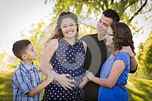 Happy Attractive Hispanic Family With Their Pregnant Mother Outdoors