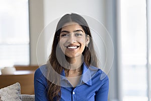 Happy attractive Indian woman looking at camera with toothy smile
