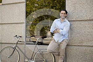 Happy attractive latin man in casual trendy clothes smiling cheerful riding on vintage cool retro bicycle