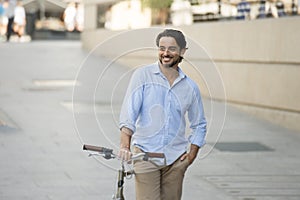 Happy attractive latin man in casual trendy clothes smiling cheerful riding on vintage cool retro bicycle