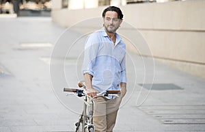 Happy attractive latin man in casual trendy clothes smiling cheerful riding on vintage cool retro bicycle