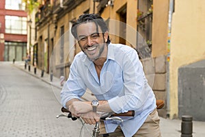 Happy attractive latin man in casual trendy clothes smiling cheerful riding on vintage cool retro bicycle