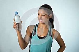 Happy and attractive latin sport woman in fitness clothes holding bottle drinking water smiling fresh and cheerful