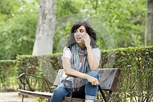 Happy attractive latin woman talking and texing on her smart phone.