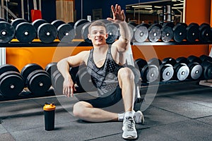 Happy attractive man resting after a workout at the gym.