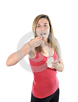 Happy attractive mature woman on her 40s eating yogurt in health concept