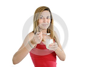 Happy attractive mature woman on her 40s eating yogurt in health concept