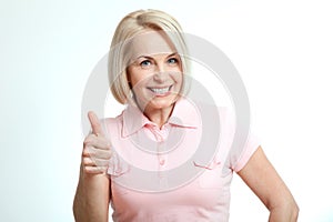 Happy attractive middle aged woman showing thumbs up, okay.