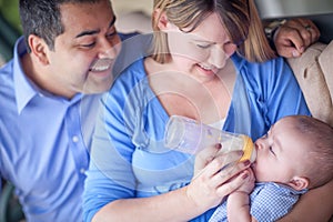 Happy Attractive Mixed Race Couple Bottle Feeding Their Baby