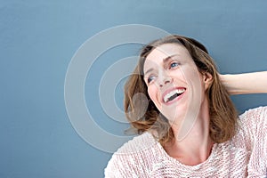 Happy attractive older woman smiling with hand in hair