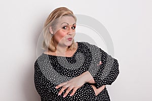A happy attractive overweight woman in studio pouting lips.