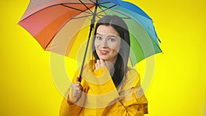 A happy attractive woman in a bright yellow raincoat