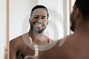 Happy attractive young African man looking and smiling at camera