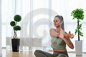 Happy attractive young business woman in active sport wear sitting on stretching muscles at her apartment after or before the work