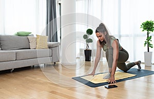 Happy attractive young business woman in active sport wear sitting on stretching muscles at her apartment after or before the work