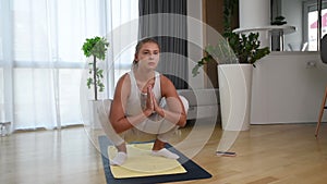 Happy attractive young business woman in active sport wear sitting on stretching muscles at her apartment after or before the work