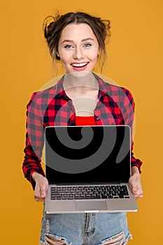 Happy attractive young woman holding blank screen laptop