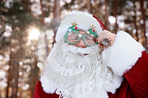 Happy Authentic Santa Claus with funny glasses outdoors