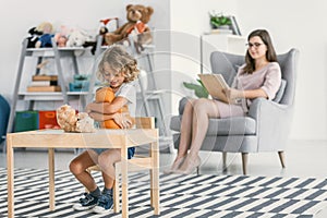 Happy autistic boy playing with a plush toy and his psychologist