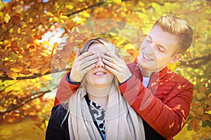 Happy autumn fall couple. Young woman girlfriend and man boyfriend having fun, enjoying outdoors. Yellow leaves.
